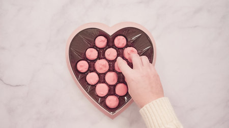 Flat lay. Heart shaped box of pink chocolated for Valentine's Day.