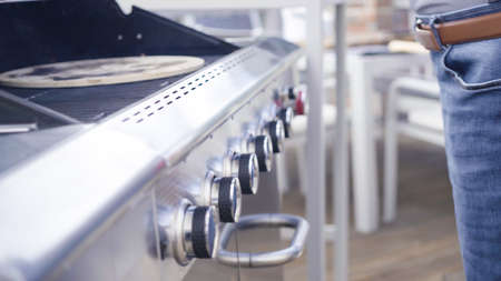 Cooking pizza on outdoor gas grill.の写真素材