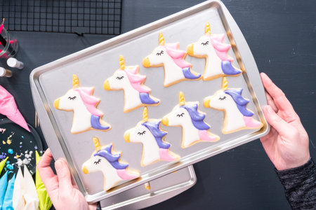 Flat lay. Decorating unicorn shaped sugar cookies with royal icing.
