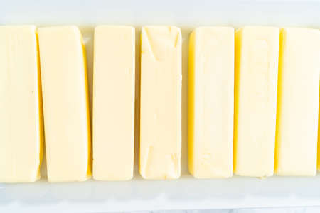 Sicks of butter brought to room temperature on a ceramic tray.の写真素材