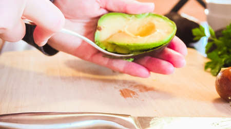 Slicing organic avocado on wood cutting board.の写真素材