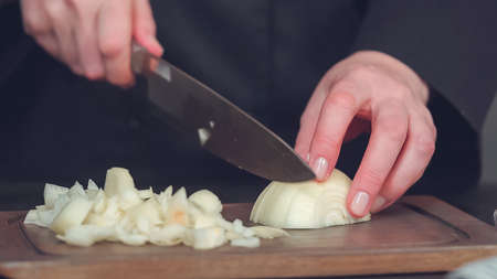 Step by step. Dicing yellow onion on a wood cutting board.の写真素材