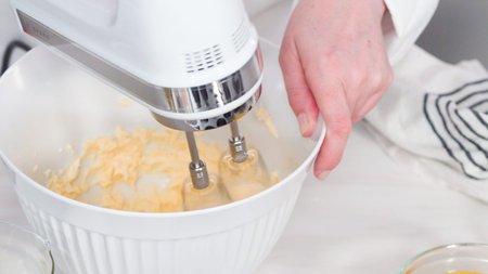 Step by step. Mixing batter to bake vanilla cupcakes with buttercream frosting.