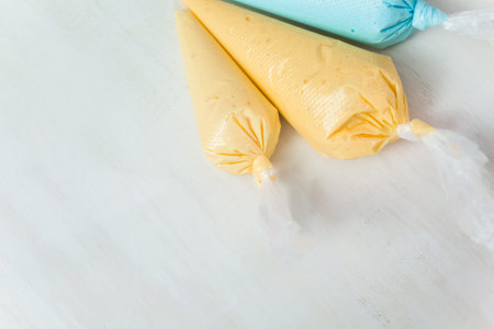 Piping bags with pastel color royal icing to decorate Easter sugar cookies.
