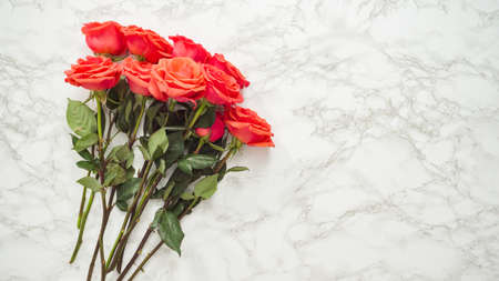 Flat lay. Florist running red roses for bouquet arrangement.の写真素材