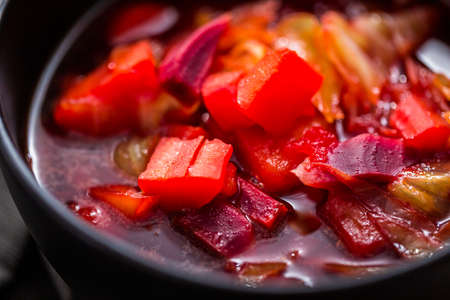 Borscht soup in a black bowl for dinner.の写真素材