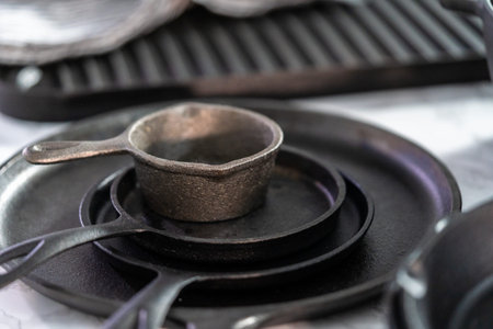 Variety of cast iron frying pans on a marble background.