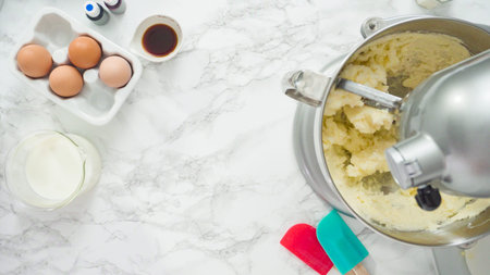 Step by step. Flat lay. Mixing ingredients in standing kitchen mixer to bake a three-layer vanilla...