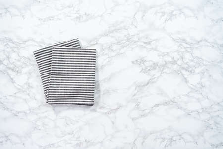 Flat lay. Kitchen towels with white and black stripes on the marble counter.の写真素材