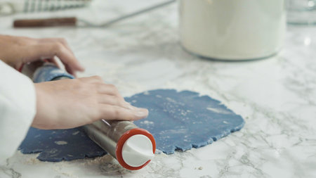 Step by step. Rolling out dough with a rolling pin to bake red, white, and blue pinwheel sugar...