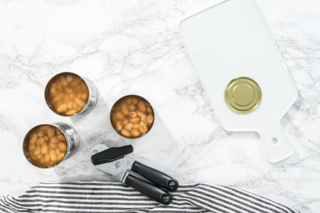Flat lay. Openning canned white beans to cook vegetarian white bean soup.