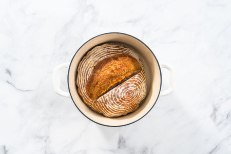 Flat lay. Freshly baked loaf of a wheat sourdough bread with marks from bread proofing basket in...