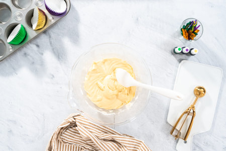 Vanilla cupcake batter in the bowl to bake Mardi Gras vanilla cupcakes.