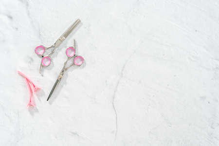 Flat lay. New barber pink scissors on a gray background.の写真素材