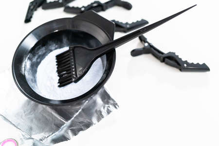 Hair color dye powder in a black plastic mixing bowl on a white background.の写真素材