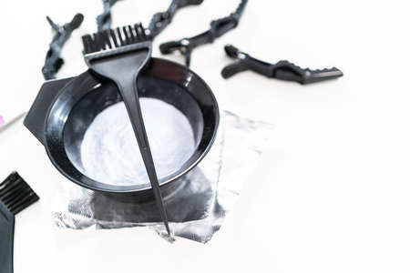 Hair color dye powder in a black plastic mixing bowl on a white background.の写真素材