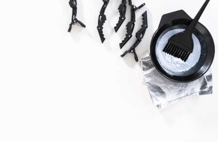 Flat lay. Hair color dye powder in a black plastic mixing bowl on a white background.の写真素材
