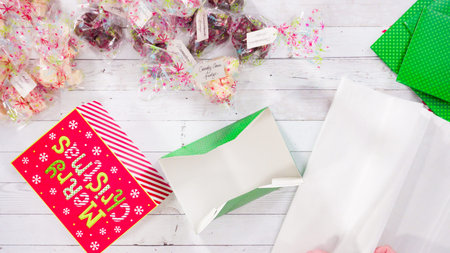 Flat lay. Step by step. Packaging homemade fudge and cookies into a Christmas gift box.