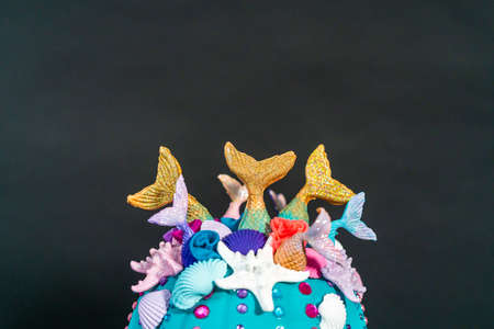 Halloween craft pumpkins decorated with mermaid tails, glitter, and sparkly rhinestones on a black background.の写真素材