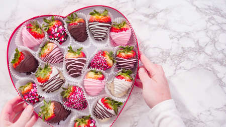 Flat lay. Step by step. Variety of chocolate dipped strawberries in a heart shaped gift box.の写真素材