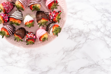 Flat lay. Variety of chocolate dipped strawberries on a pink cake stand.