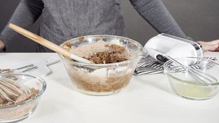 Step by step. Mixing ingredients in a glass mixing bowl to bake chocolate cookies.