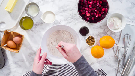 Flat lay. Step by step. Mixing ingredients in a mixing bowl to bake cranberry muffins.