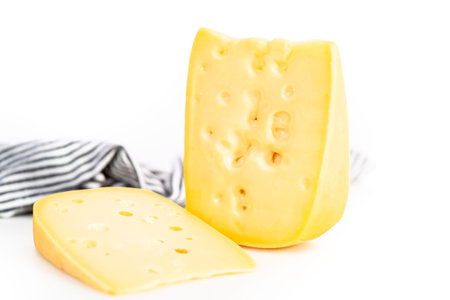 Large slice of semi soft part skim cheese on a white background.
