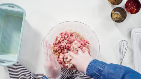 Flat lay. Step by step. Mixing ingredients for a classic beef meatloaf recipe in a glass mixing...