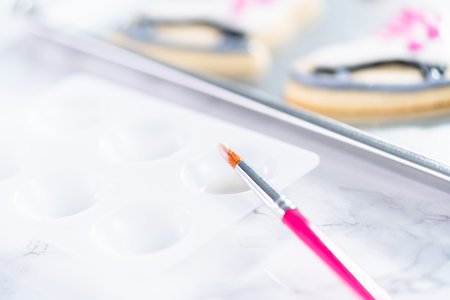 Decorating sugar cookies shaped as figure skates with royal icing.の写真素材