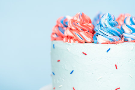 Red, white, and blue round cake frosted with buttercream frosting.の写真素材