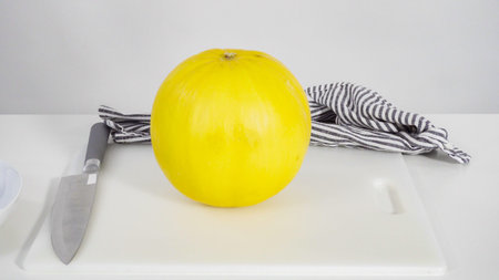 Step by step. Whole golden dewlicious melon on a white background.