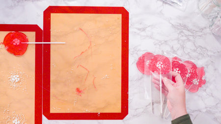 Flat lay. Wrapping large homemade lollipops into clear gift bags.の写真素材