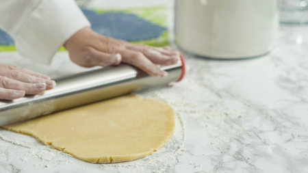Step by step. Rolling out dough with a rolling pin to bake red, white, and blue pinwheel sugar...