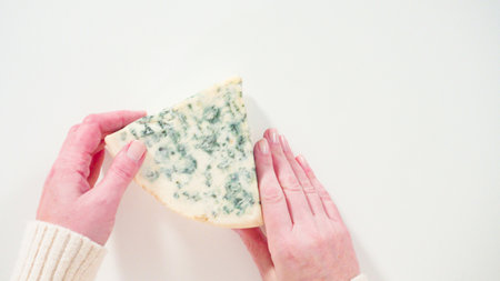 Flat lay. Large slice of gourmet cheese on a white background.の写真素材