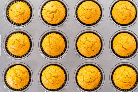 Freshly baked pumpkin spice cupcake cooling in cupcake pan.の写真素材