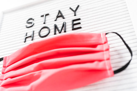 STAY HOME sign on message board with a homemade face mask.の写真素材
