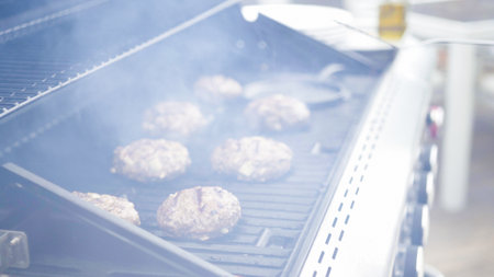 Cooking hamburger beef patties on a gas grill.の写真素材