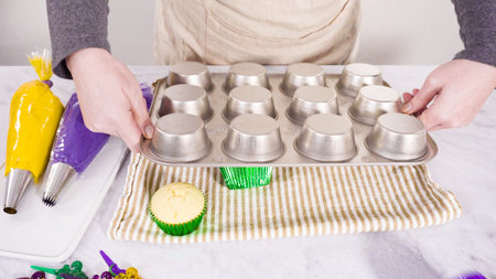 Step by step. Frosting vanilla cupcakes with Italian buttercream icing for Mardi Gras celebration.