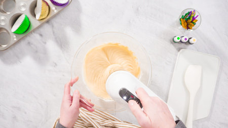 Flat lay. Step by step. Mixing ingredient in a mixing bowl with an electric mixer to bake vanilla...