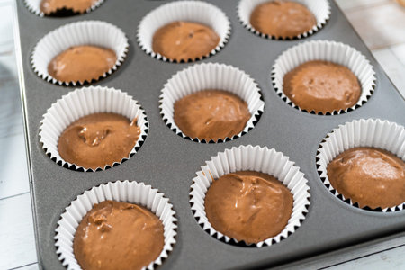 Scooping dough into the foil cupcake liners to bake chocolate raspberry cupcakes.