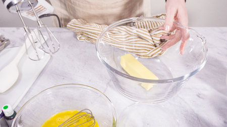 Step by step. Mixing ingredient in a mixing bowl with an electric mixer to bake vanilla Mardi Gras cupcakes.の写真素材