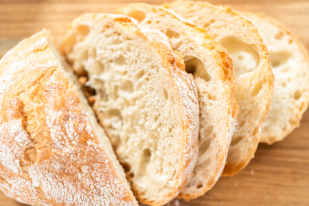 Sliced fresh loaf of bread on a wooden cutting board.