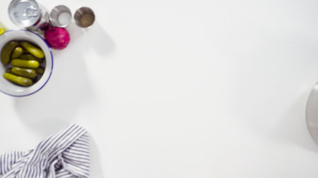 Flat lay. Step by step. Cutting cookies vegetables on a white cutting board for vinaigrette salad.の写真素材