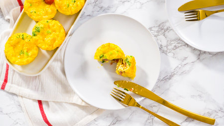 Step by step. Flat lay. Bacon and cheese egg muffin on a white plate.の写真素材