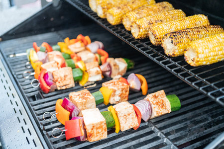 Grilling vegetarian tofu kebab with vegetables marinated in spicy sauce.