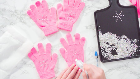 Flat lay. Rhinestone pink kids gloves with snowflake shapes.の写真素材
