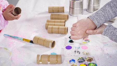 Kids papercraft. Painting empty toilet paper rolls with acrylic paint to create paper bugs.