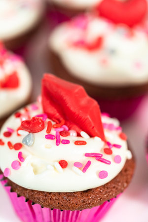 Red velvet cupcakes with cream cheese frosting and decorates with heart and kiss shaped red...