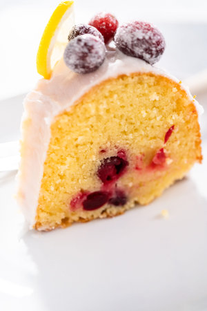 Slice the lemon cranberry bundt cake on a white plate.の写真素材